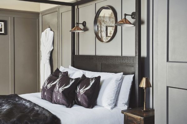 Gorgeous Hotel Room With Four Poster Bed. Dressing gown hanging on the door behind the bed.