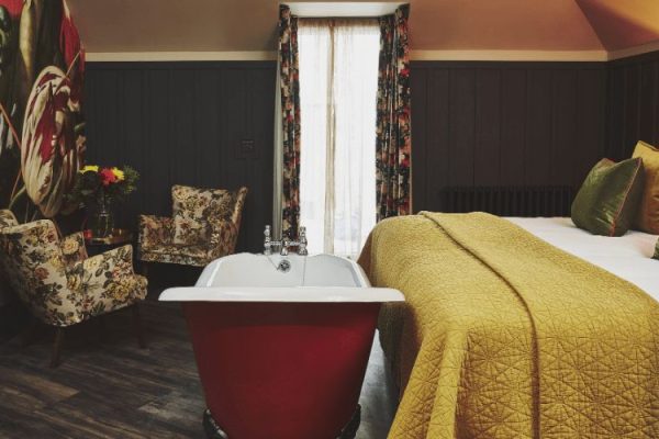 Gorgeous Room With Freestanding Bath & King Size Bed. The red bath is directly in front of the bed.